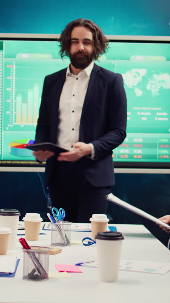 Empresario que presenta datos y gráficos en una tablet durante una reunión en la oficina