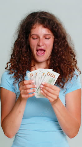 woman hold dollar cash money smiling satisfied celebrating salary savings loan financial success joy