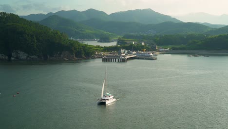 tourist boat sailing near catamaran belvedere hotel and port in geonje city south korea - wide shot
