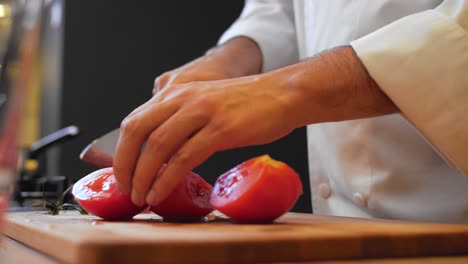 el cocinero está cortando tomates.