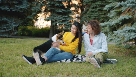 couple enjoying a picnic with their dog in the park