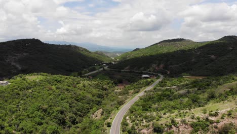 aerial shot of mountainous green landscape and highway