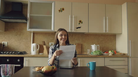 Woman reading document in kitchen