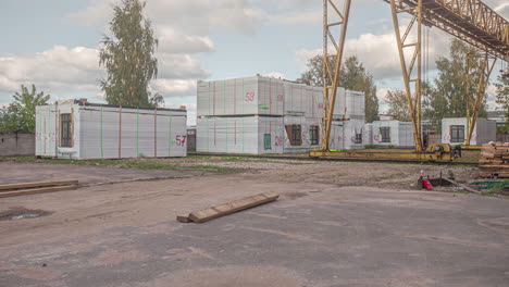 workers shifting modular cabin house by crane and truck in a sunny day