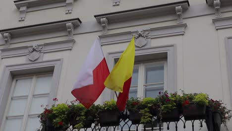 polish and warsaw flag fluttering exposed from the house in the wind