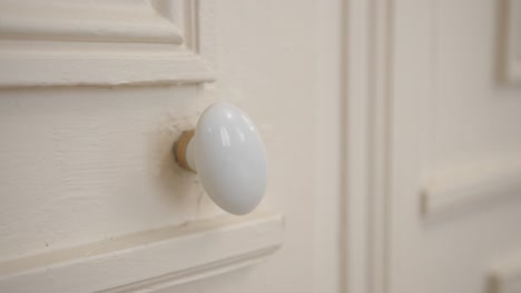 moving door knob of a white door, scary and mysterious