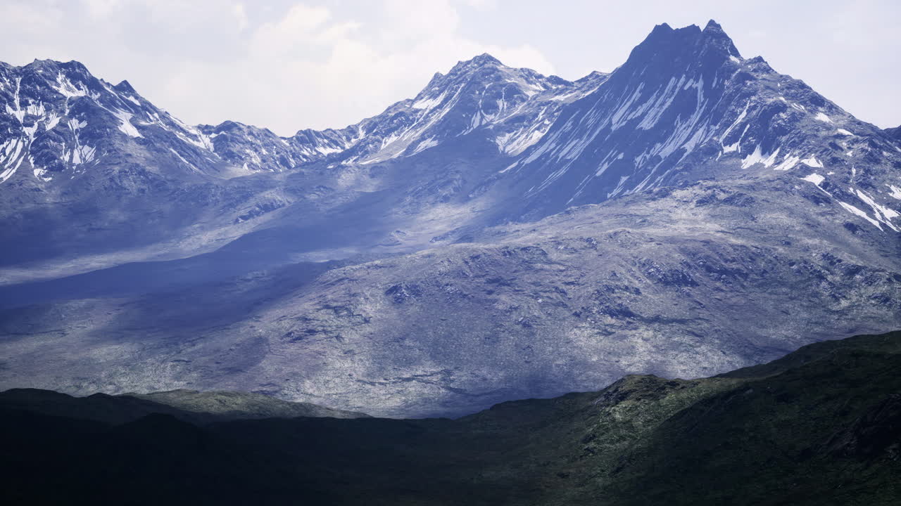 Stunning mountain range under a cloudy sky with snow capped peaks