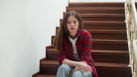 shy woman sits on building staircase. student with obsessive thoughts about future tests sits on steps. lady in casual clothes with nervous expression