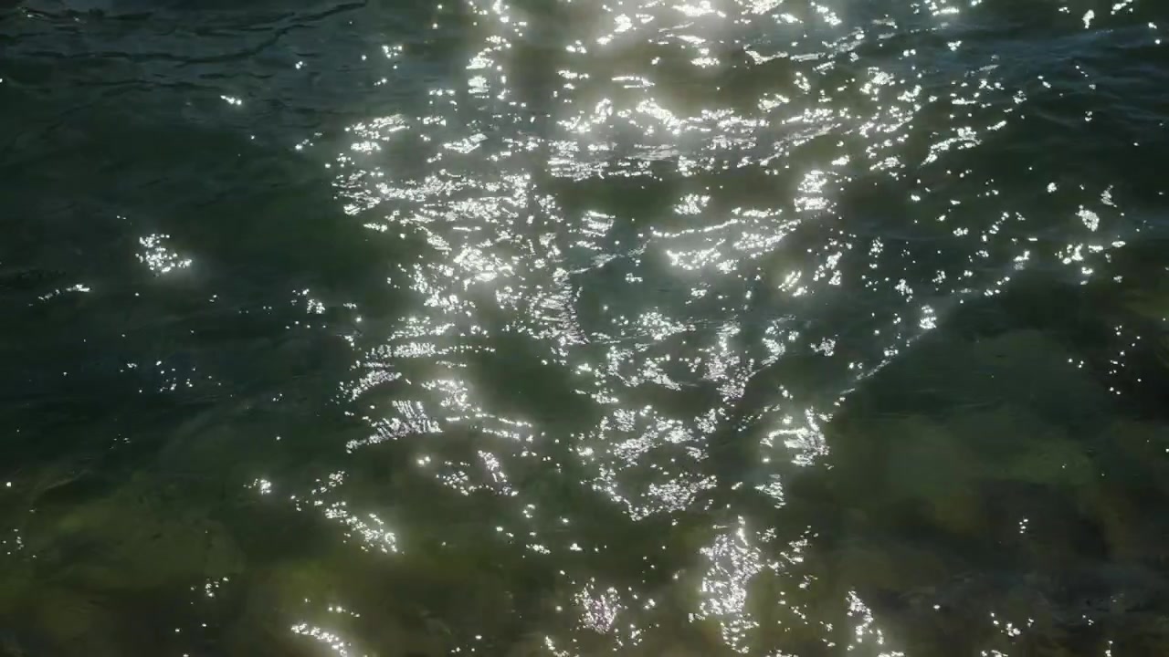 Luce solare che si riflette sull'acqua in movimento creando riflessi scintillanti e un'atmosfera calma e naturale