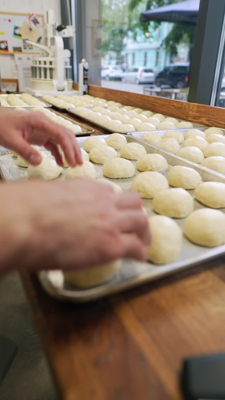 Baker arranging dough on baking trays