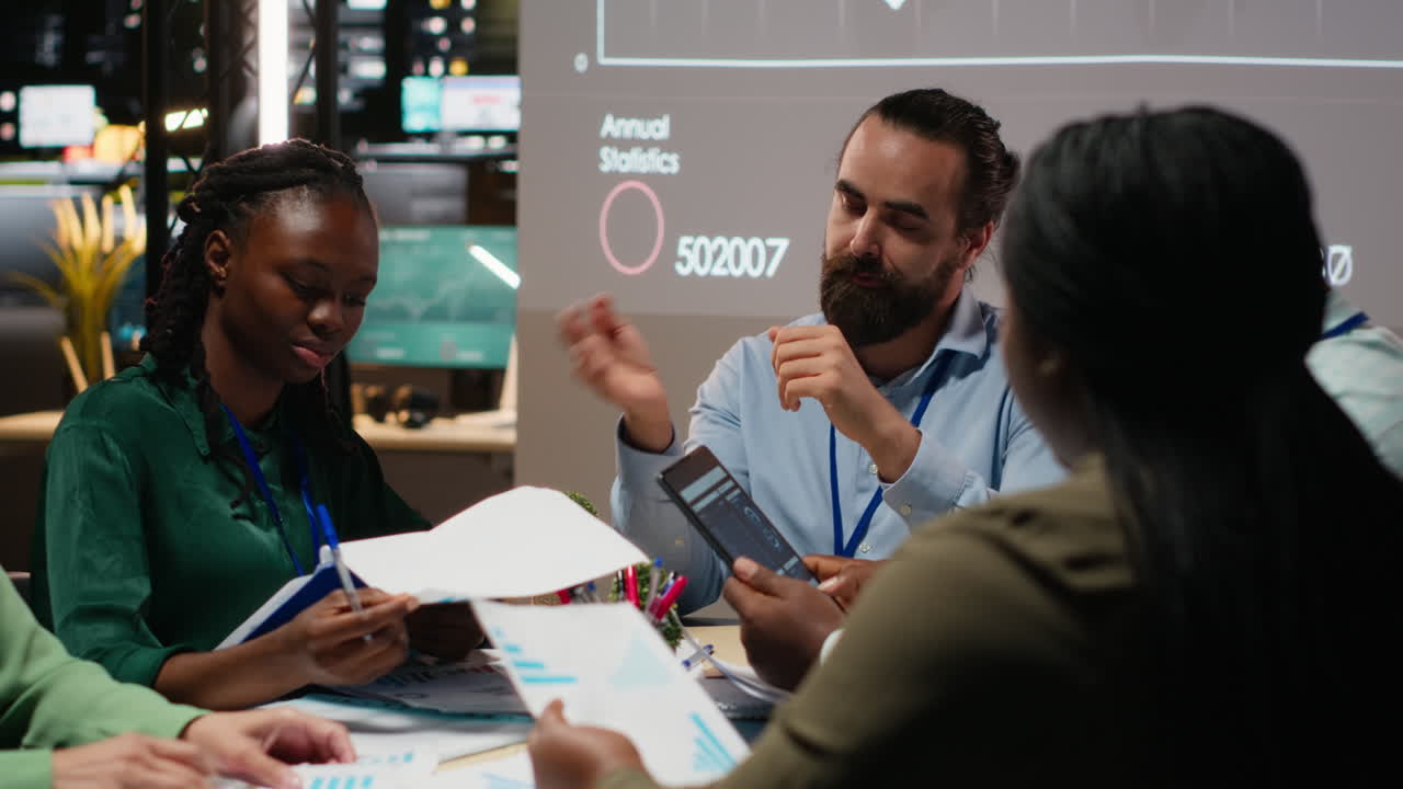 Business people prepare for a pitch by studying financial data on files reports