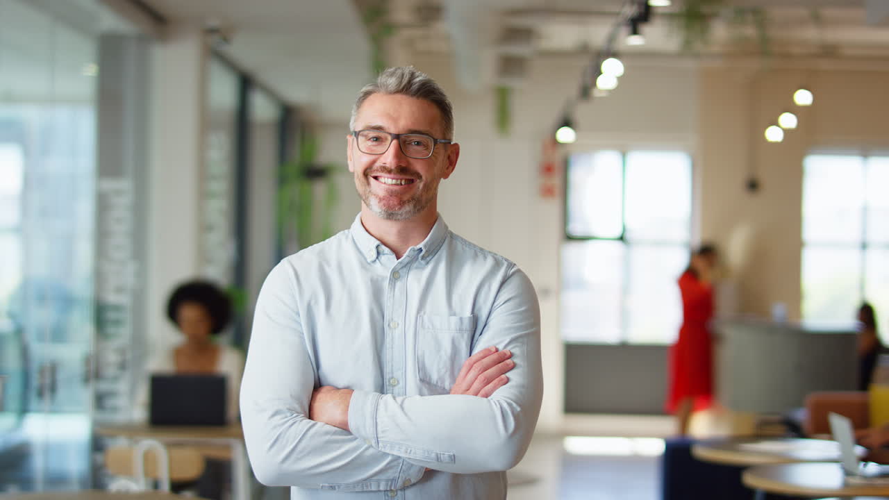 retrato de un hombre de negocios maduro sonriente de pie en una oficina moderna de plan abierto