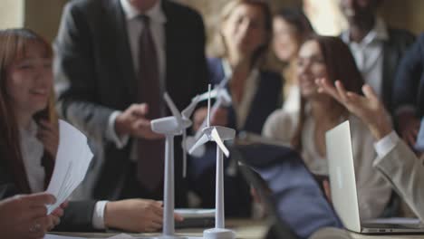 model windmill turbines in motion - professor in the background giving less to young engineers students