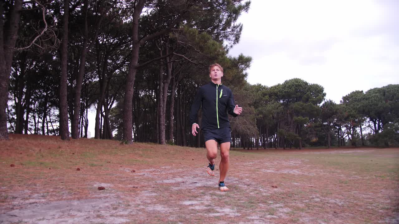 Man Jogs Past with Trees in Background