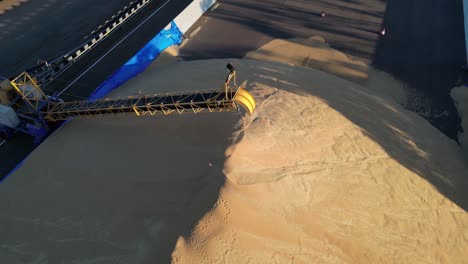 drone flying over big pile of grain in storage and distribution center