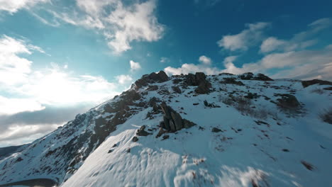 Carretera-De-Montaña-Cubierta-De-Nieve-Con-Un-Cielo-Azul-Claro-Capturado-Desde-Un-Dron