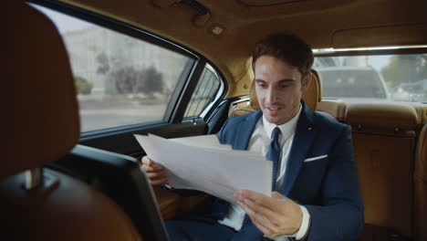 smiling male professional rejoicing at good record in paperwork