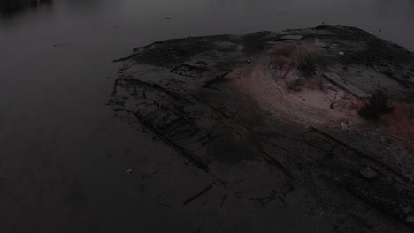 Dark-gloomy-boat-skeleton-in-low-tide