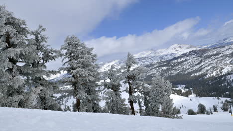 Timelapse-of-clouds-rolling-over-mountain-tops-and-snow-covered-trees