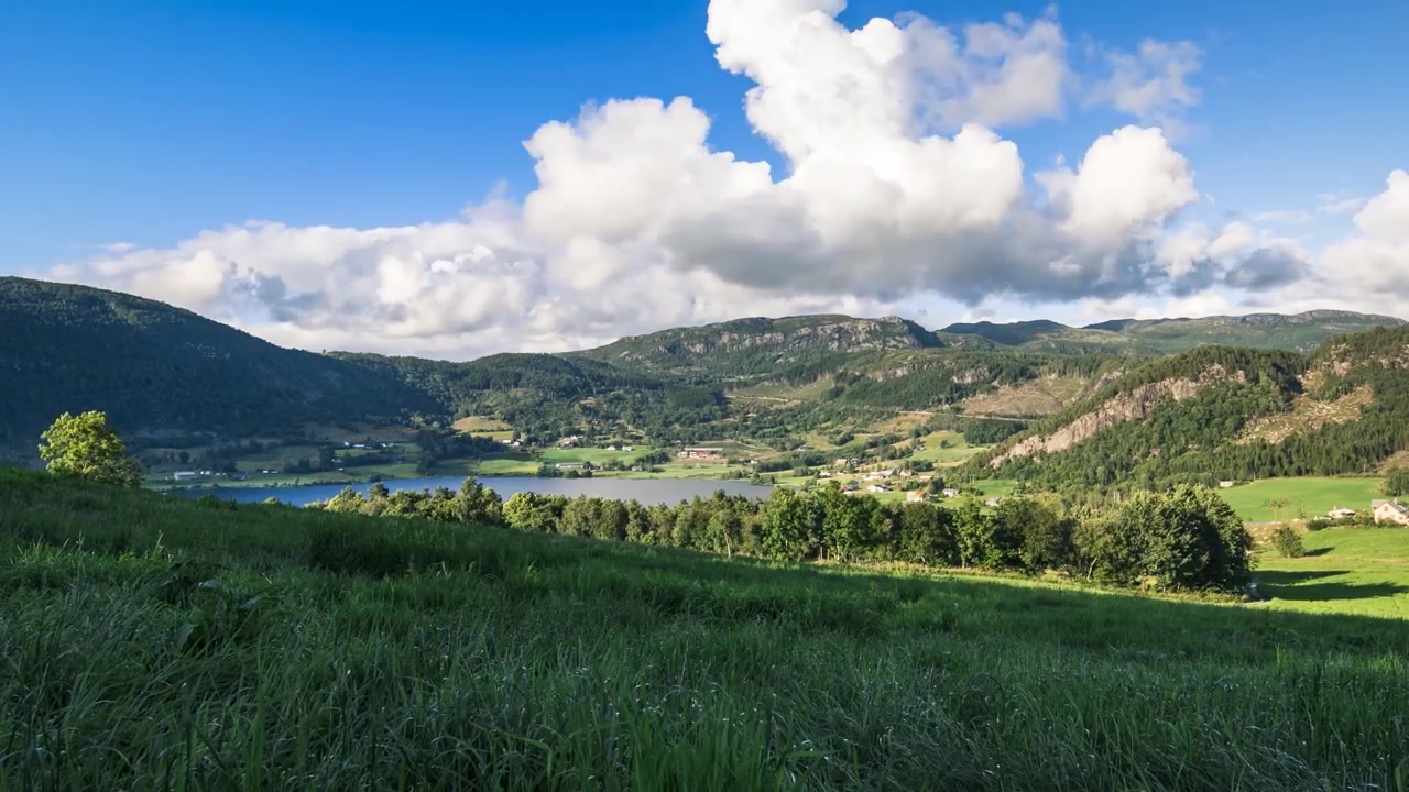 Wunderschöner Zeitraffer von Wolken, die sich an einem sonnigen Tag über den Himmel bewegen, gesehen von einem Feld in einer gemütlichen norwegischen Landschaft