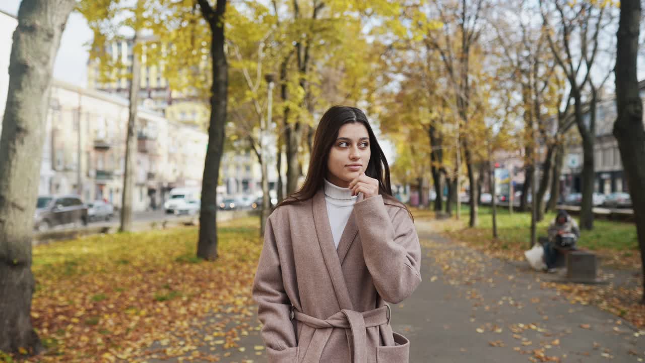 Donna che cammina in un parco cittadino autunnale