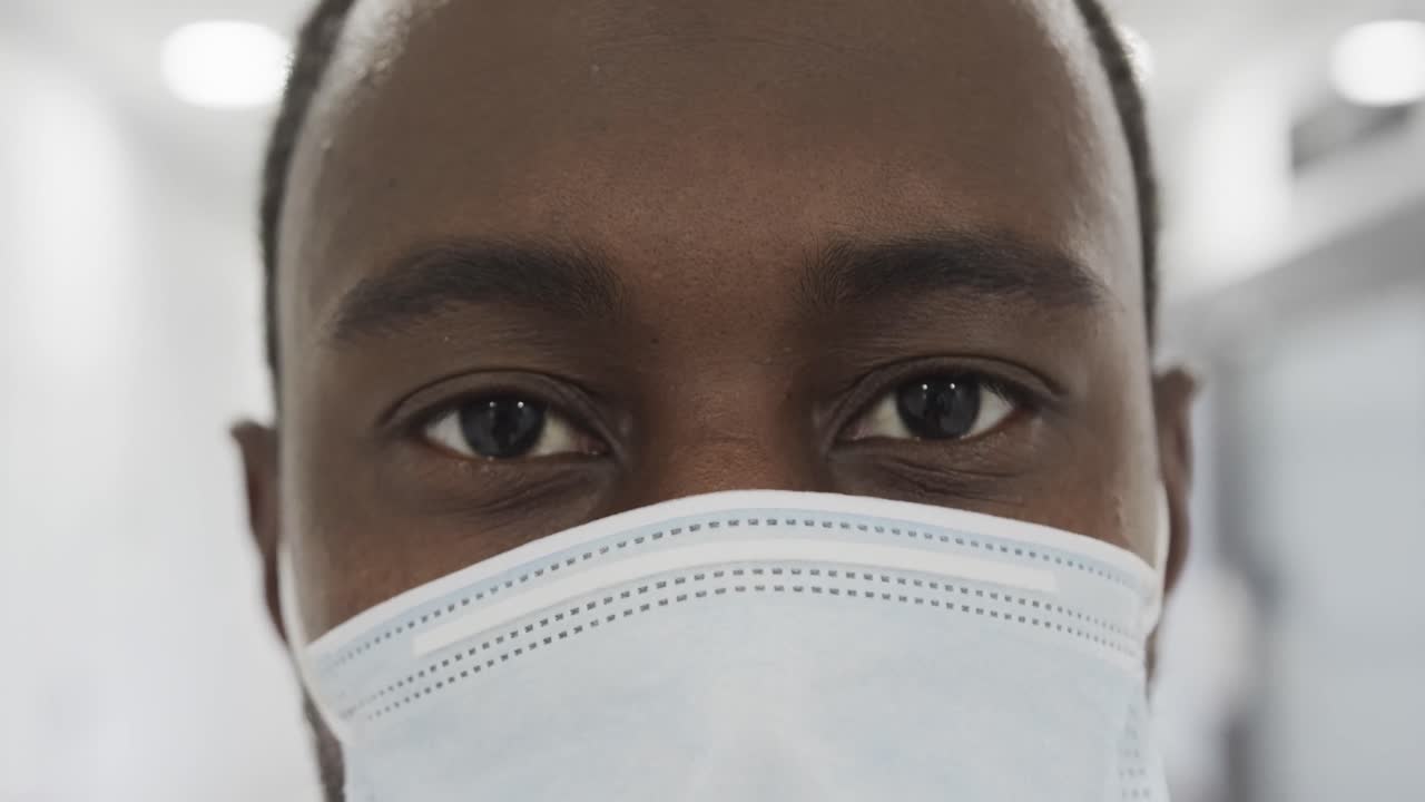 retrato de los ojos de un médico afroamericano con máscara facial en un hospital, cámara lenta