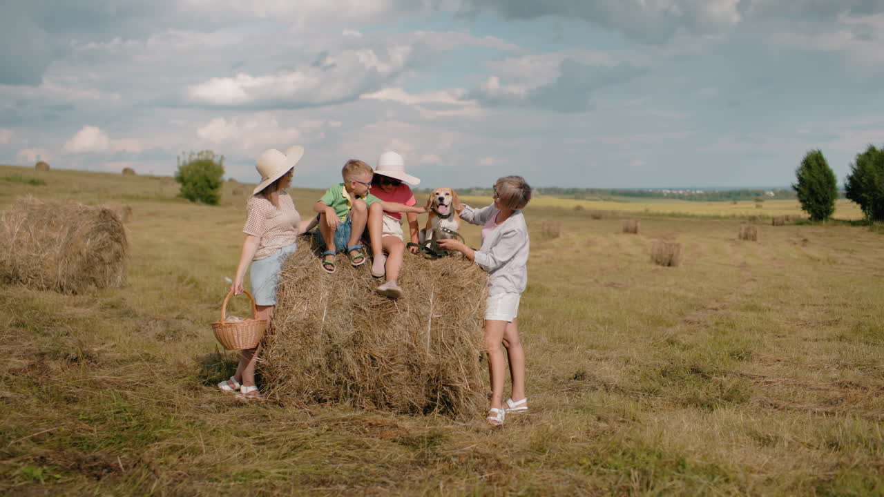 가족은 시골의 피크닉을 즐기고, 할머니는 개에게 먹이를 주고, 소년은 손을 내밀고, 여자는 피크닉 바구니를 들고,  모자를 입은 아이들은 미소 짓고, 열린, 어져있는 알.