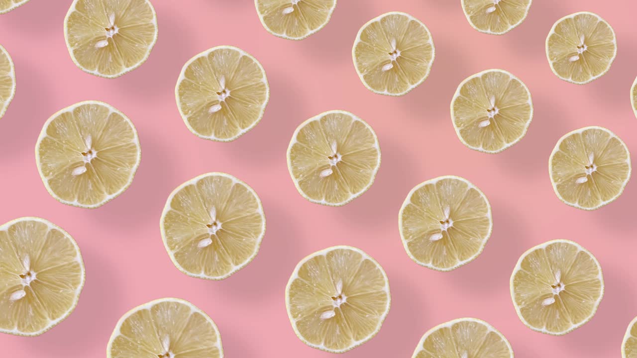 Motivo di frutta colorato di limoni freschi su sfondo rosa con ombre. Motivo senza soluzione di continuità con fette di limone. Animazione realistica. Video in movimento 4K.