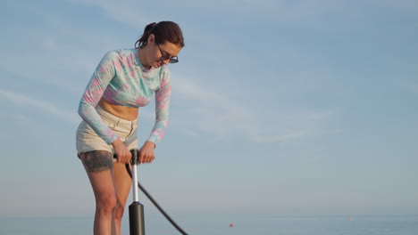mujer inflando un barco en la playa