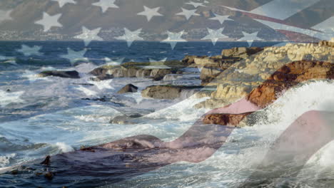 digital composition of waving us flag against sea waves hitting the rocks