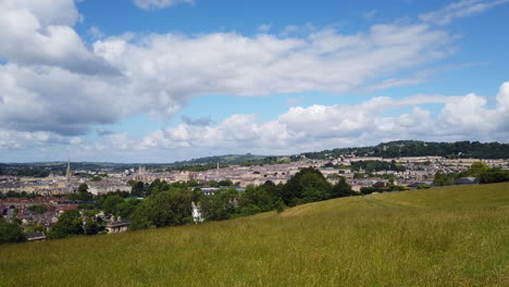 Right-to-Left-Pan-Shot-of-the-City-of-Bath-Skyline-from-Hillside-Lookout-on-a-Sunny-Summer’s-Day-with-Blue-Sky---White-Fluffy-Clouds