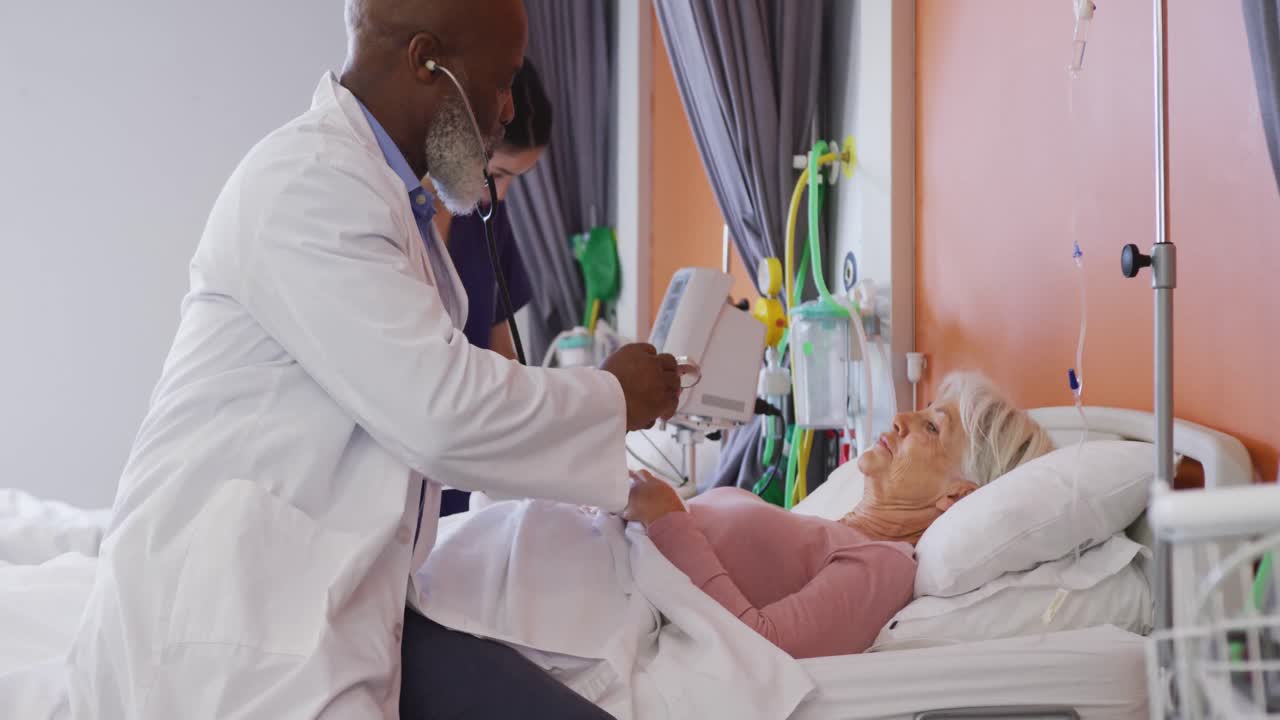 African american male doctor with stethoscope examining senior caucasian female patient at hospital