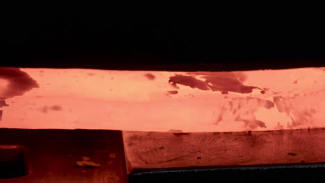primer plano herrero martillando metal al rojo vivo