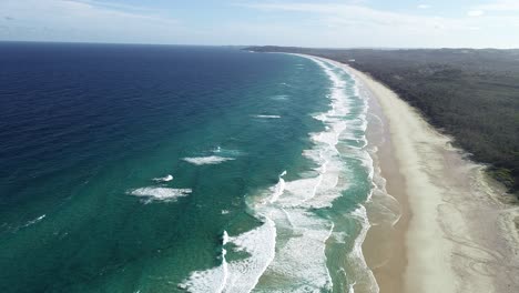 Luftaufnahme-Von-Oben-Auf-Einen-Weißen-Sandstrand,-Rollende-Wellen-Und-Schöne-Vegetation