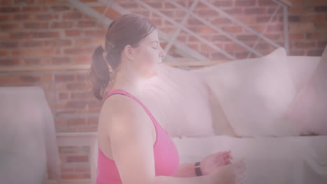 animation of flickering lights over woman exercising and meditating with eyes closed at home