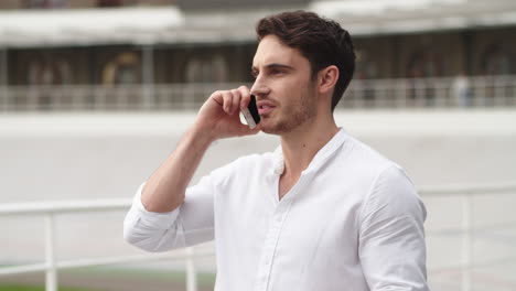 Serious-businessman-talking-mobile-phone-outdoors.-Young-business-man