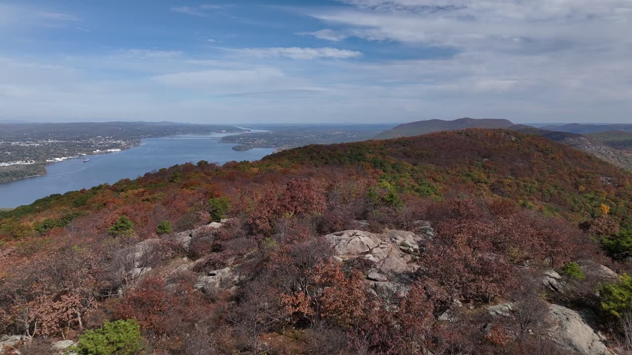 una vista aérea muy por encima de las montañas en el norte del estado de nueva york durante los cambios de follaje de otoño en un hermoso día con nubes blancas