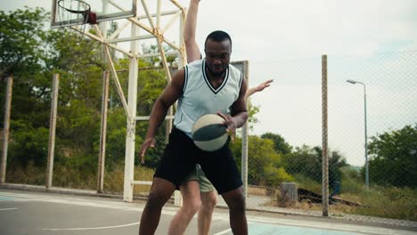 dynamic game of basketball one of the players bypasses the other and scores a brilliant goal game at the basketball flat in the summer