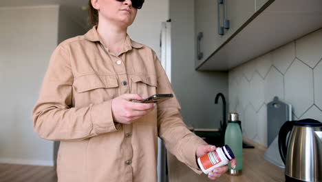 blind woman with glasses using mobile app to read product label at home