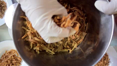 Hands-putting-corn-chips-in-many-bowls