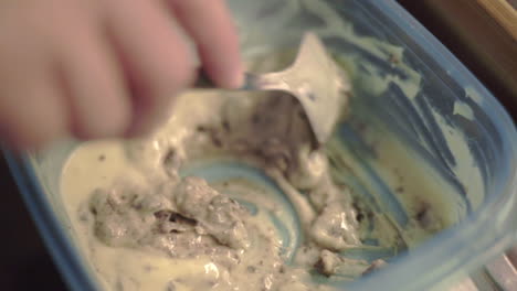 mixing cookie pancake batter in a plastic container with a spoon - closeup shot