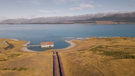 Two-pipelines-leading-down-towards-Tekapo-B-hydro-power-station-in-warm-sunshine