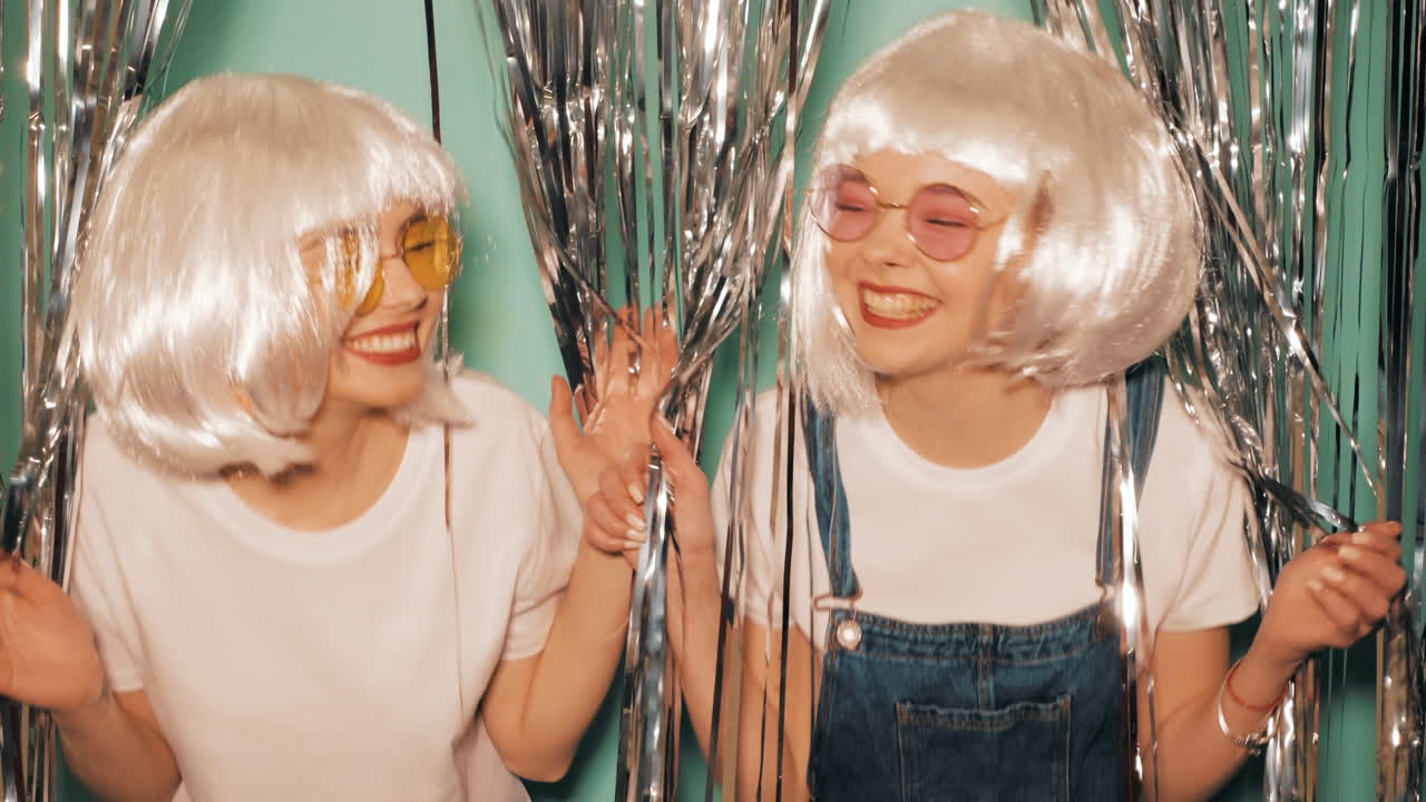 두 친구가 파티에서 즐거움을 나누고 있다