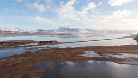 Snowy-Mountain-Background,-Aerial-Drone-Fly-Above-Volcanic-Water-Sky-Reflection