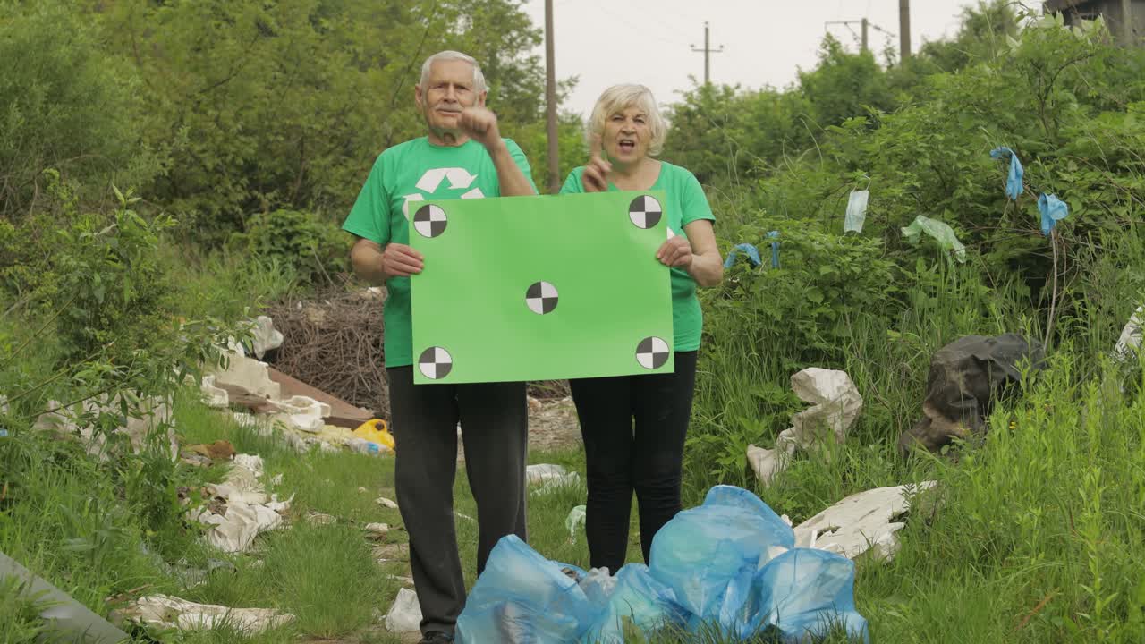 un equipo de voluntarios mayores sostiene un cartel de protesta de chroma key. reducir la contaminación plástica de la basura de la naturaleza