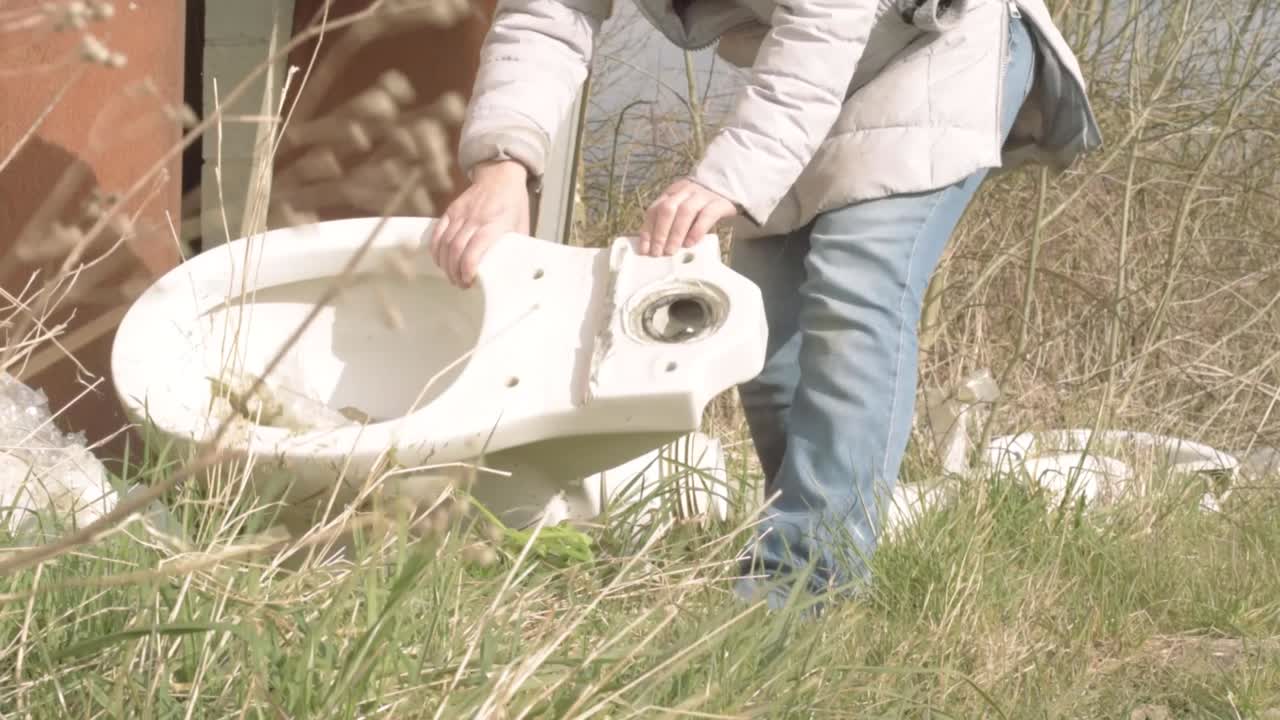 Person fly tipping white toilet