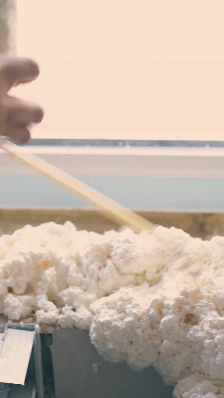 CU shot: professional constructor applies fixing foam insulation on windowsill at construction in light room close view
