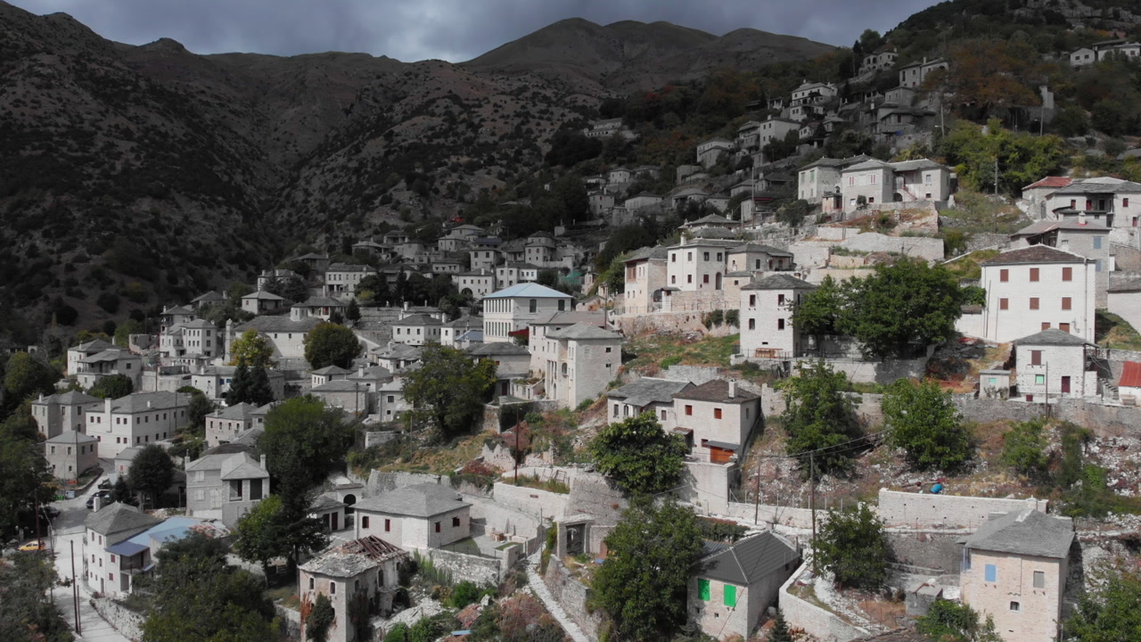 Syrrako village's stone houses cascade down a Greek mountain, offering a tranquil and historic ambiance. Ideal for travel and cultural content.