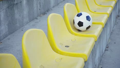 bola de fútbol en el podio del estadio. sillas amarillas vacías