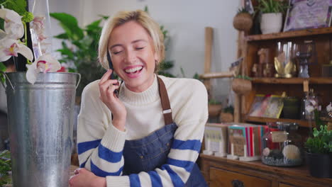 propietaria de una floristería hablando por teléfono móvil